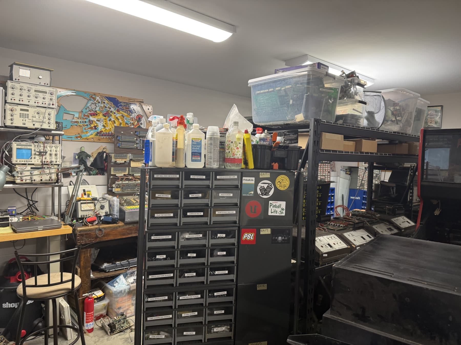 Organized pinball parts and diagnostic equipment in the shop